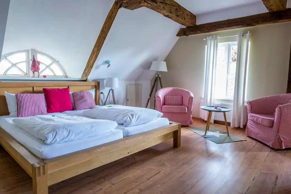 Doppelzimmer mit Holzbalken auf dem Traditionshof Gut Schöneworth